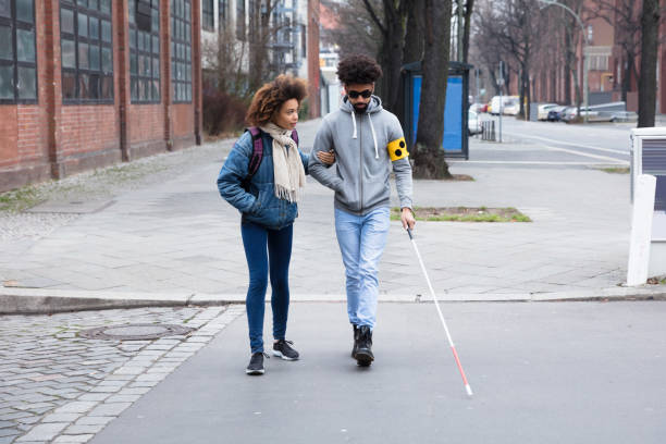 how can you help a blind person to cross a busy road